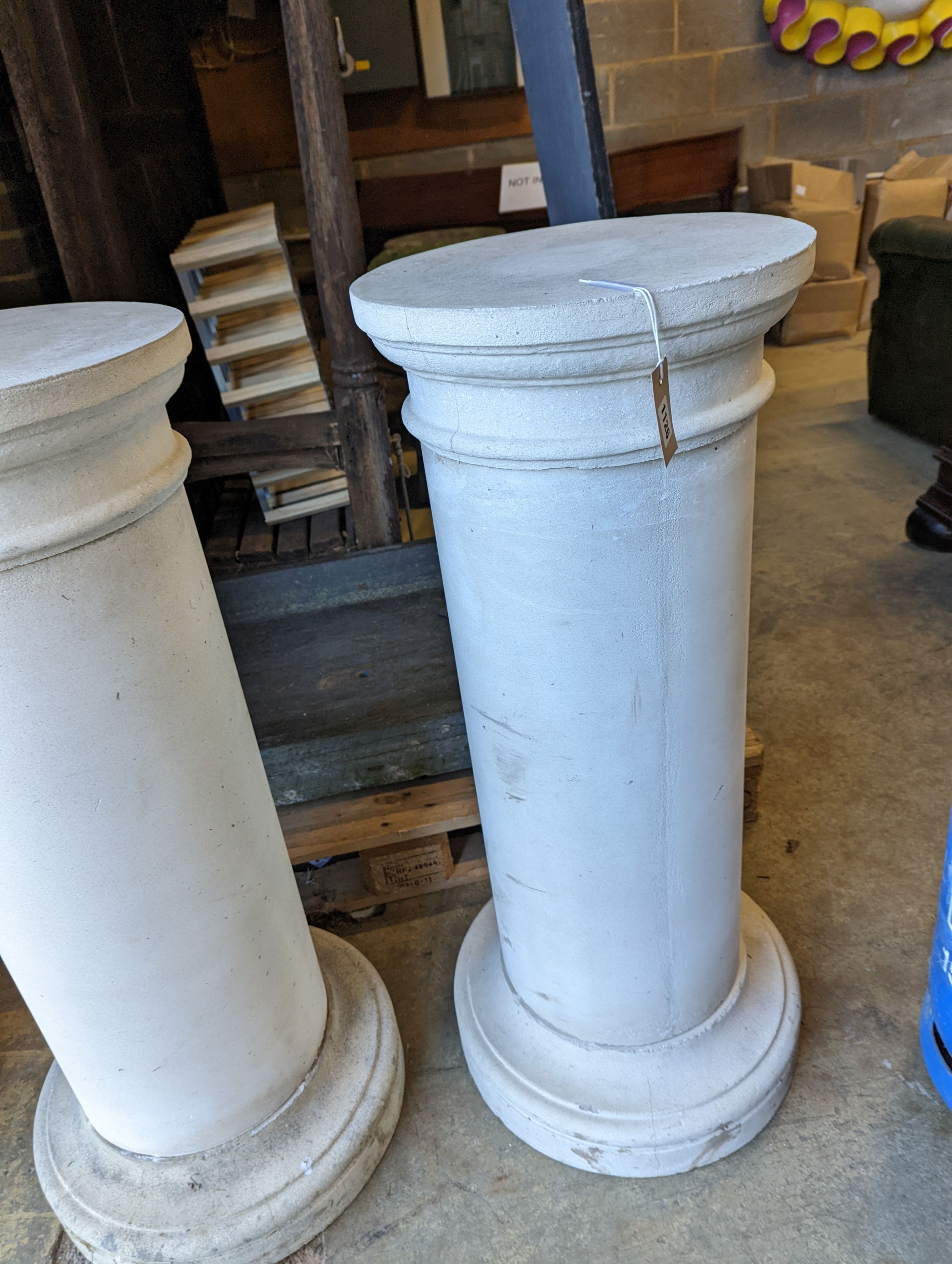 A pair of circular stone pedestals, tops 38cm diameter, height 99cm